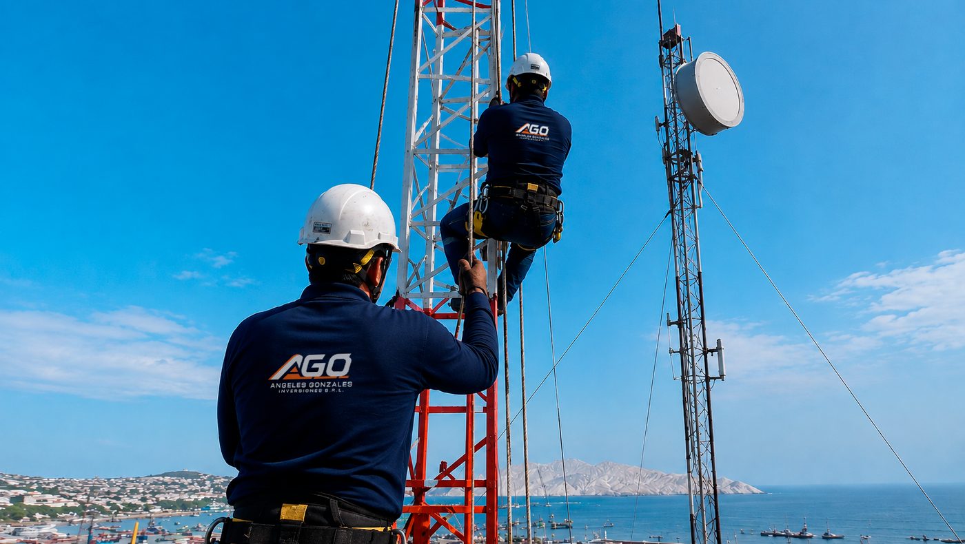 Dos técnicos de AGO trabajando en una torre de antenas frente a la bahía de Chimbote.